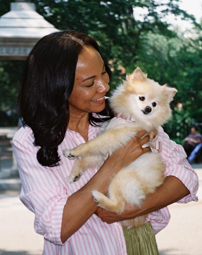Kvinna utomhus som håller i en liten fluffig hund